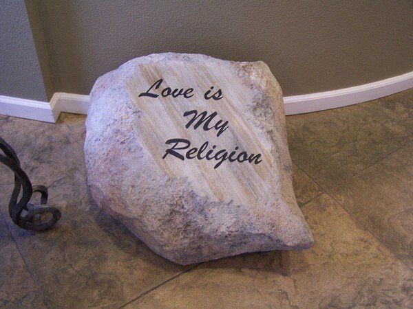 A large rock that says love is my religion on it