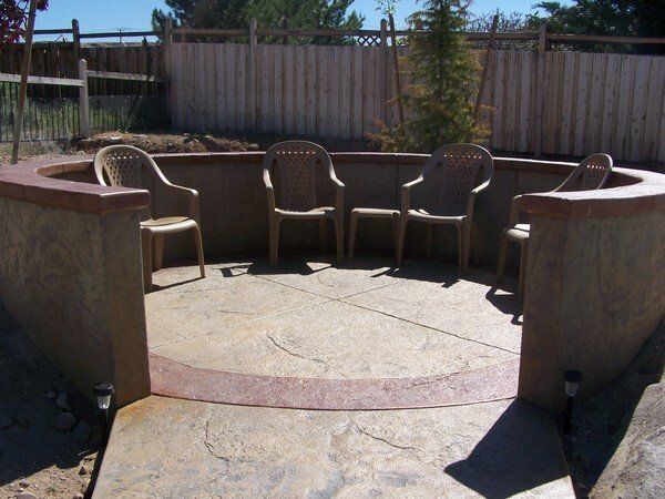 A patio with chairs and a fence in the background