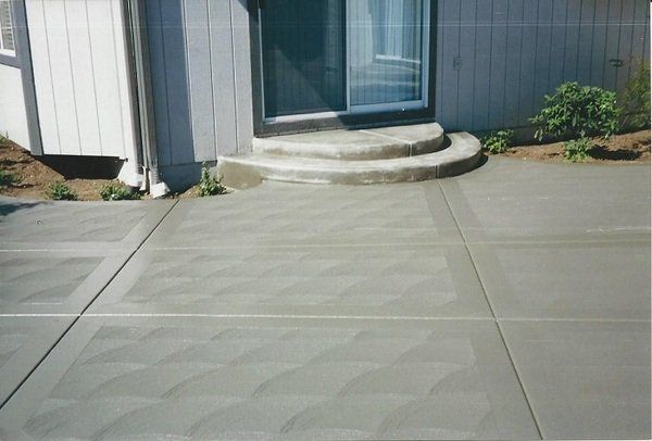 A concrete driveway with steps leading to a door