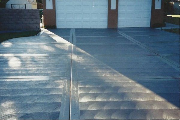 A concrete driveway in front of a garage door