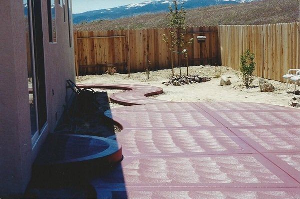 A patio with a wooden fence and mountains in the background
