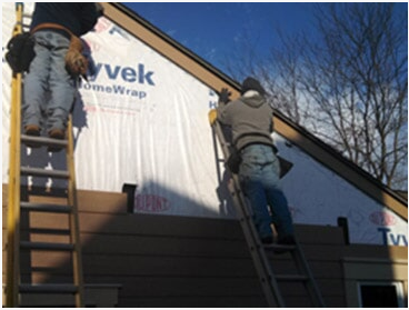 Siding Restoration — Men Fixing Exterior Of A House in Waukesha, WI