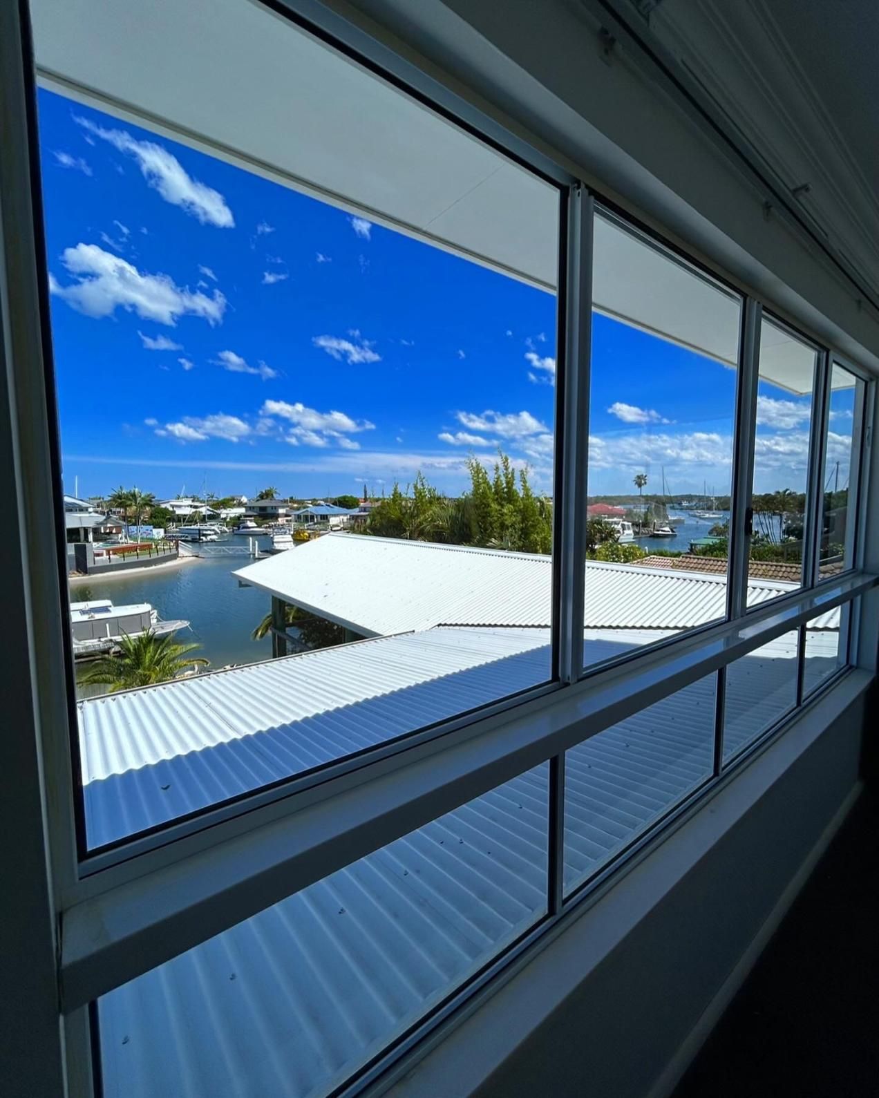 A Large Window With A View Of A Body Of Water — Pristine and Co In Sanctuary Cove, QLD
