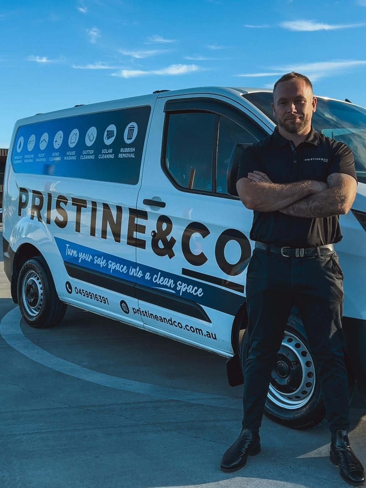 A Man Is Standing In Front Of A White Van With His Arms Crossed — Pristine and Co In Coomera, QLD
