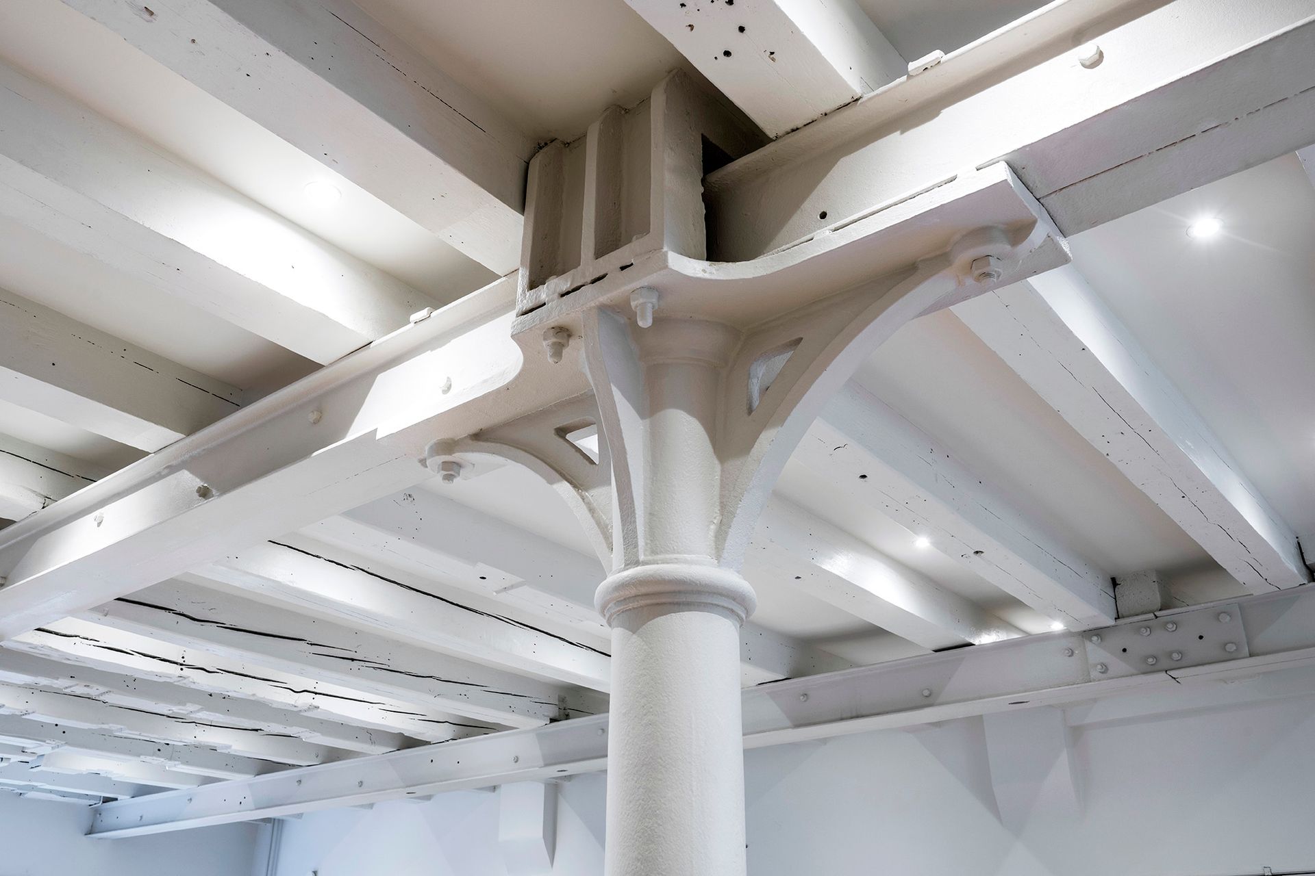 a ceiling with white beams and a white column