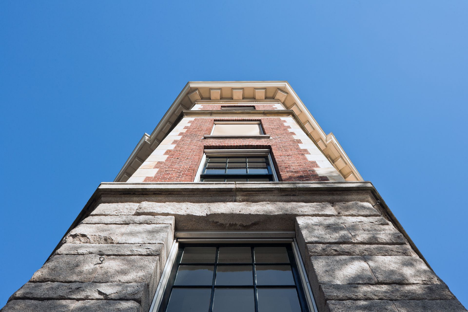 looking up at a tall brick building with a blue sky in the background