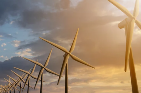 a row of wind turbines against a cloudy sky