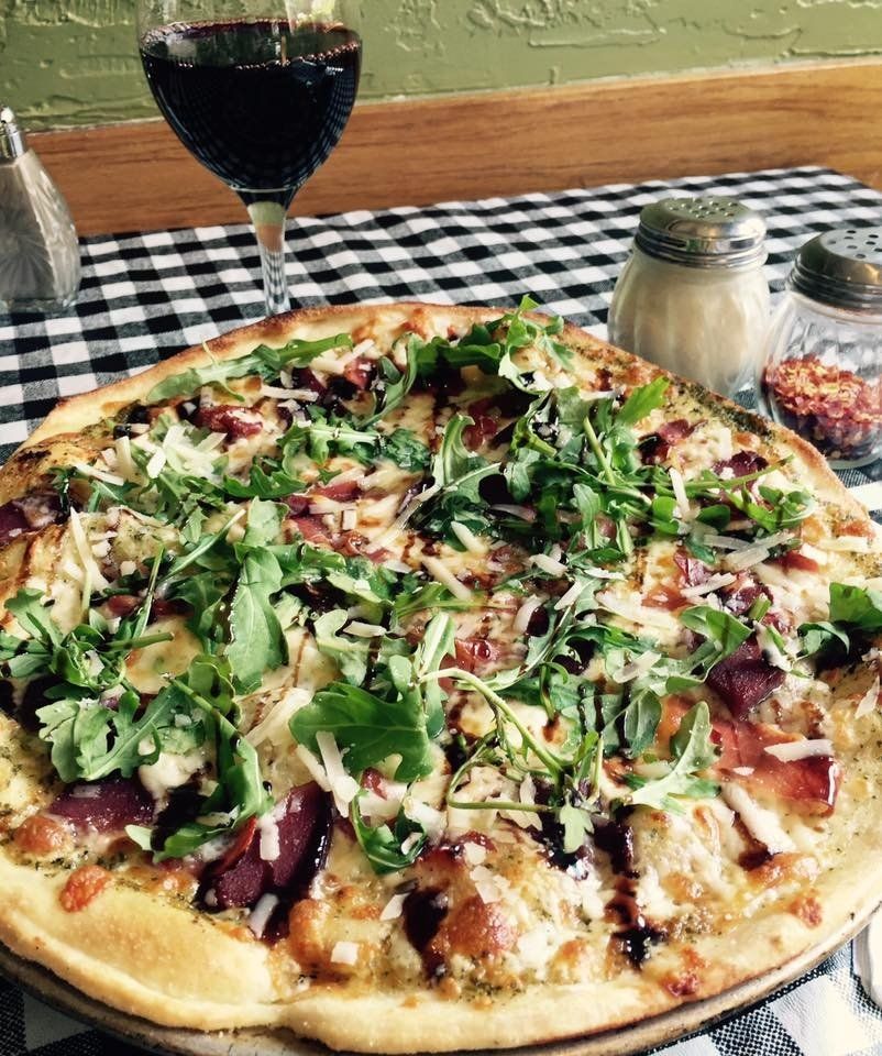 large pizza topped with vegetables, sauce and lettuce