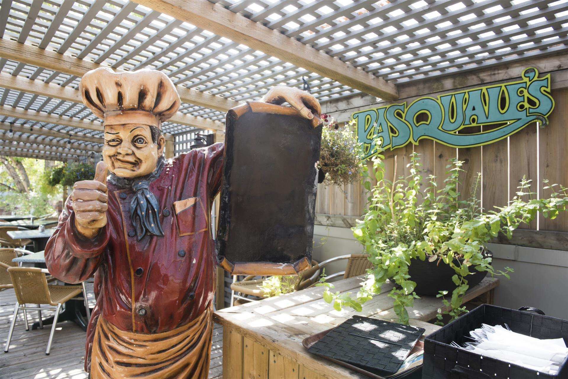 Chef Statue posing on roof top infront of outdoor seating