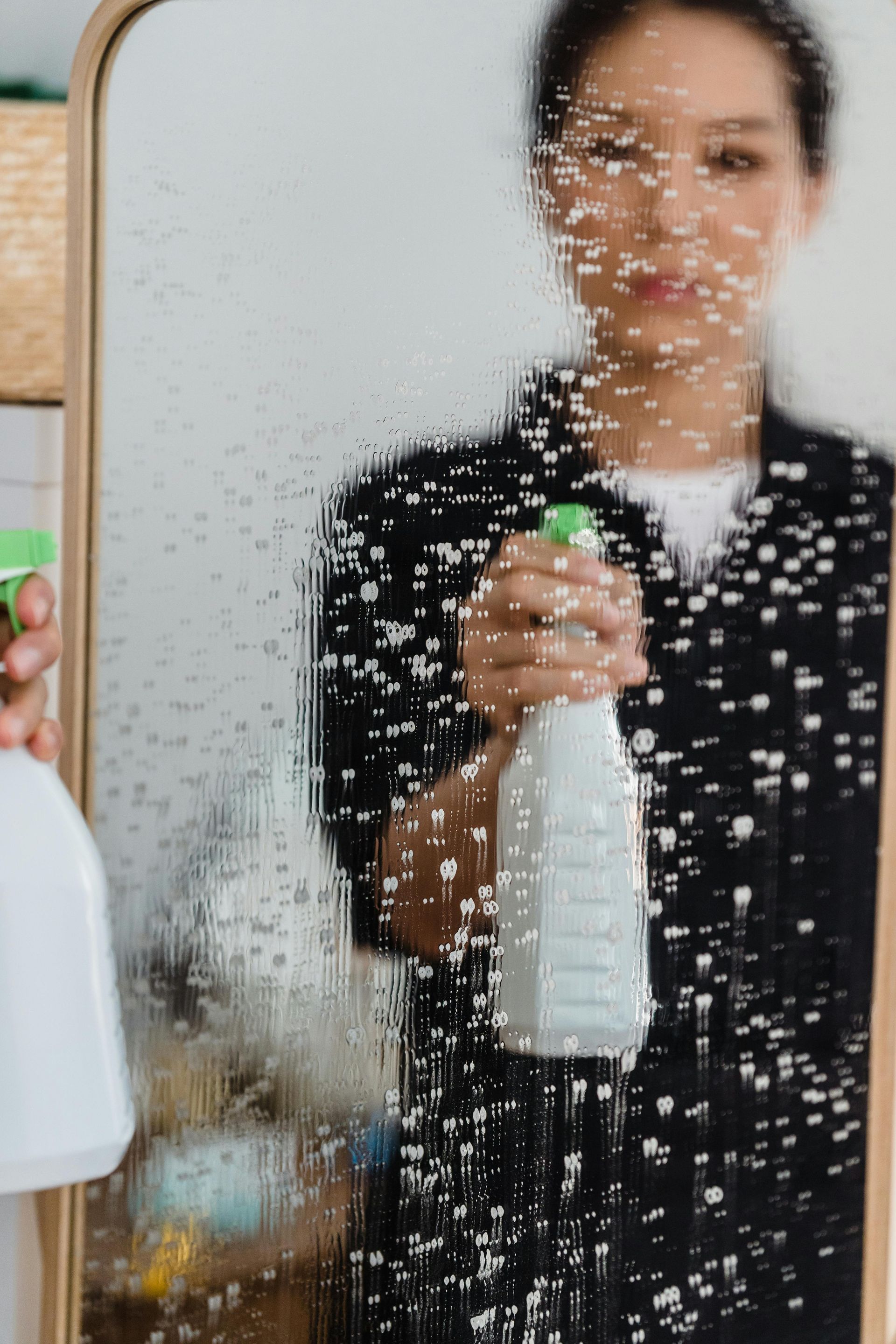 spraying mirror to clean 