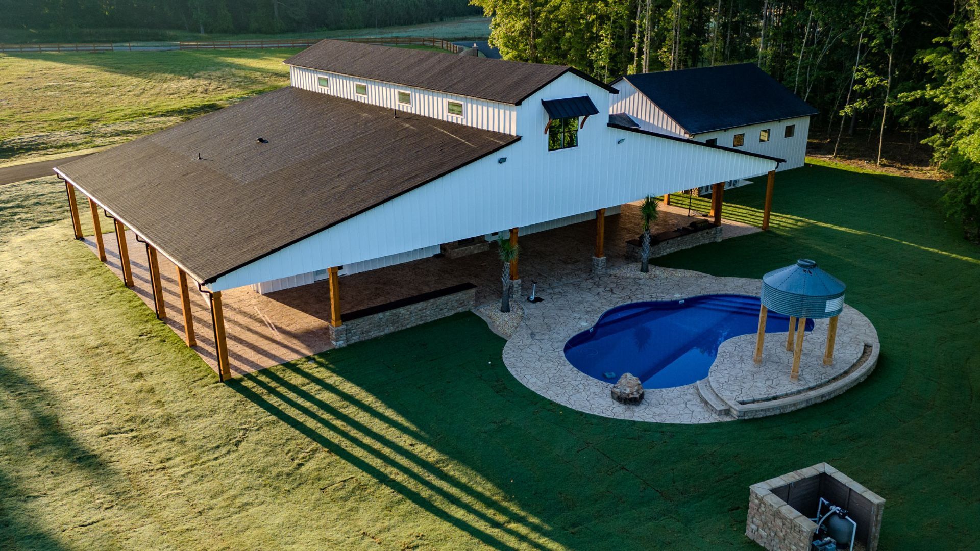 An aerial view of a house with a pool in the backyard.