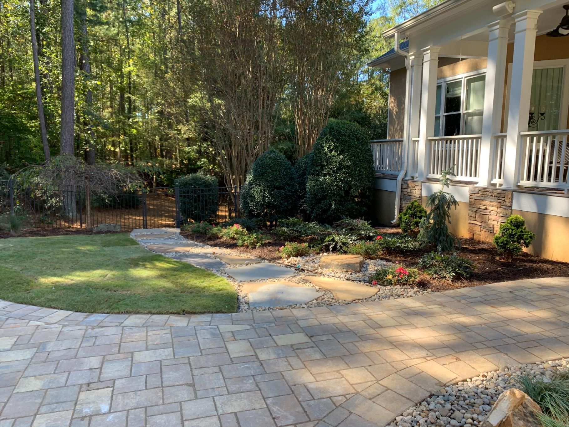 There is a brick walkway leading to the front of the house.