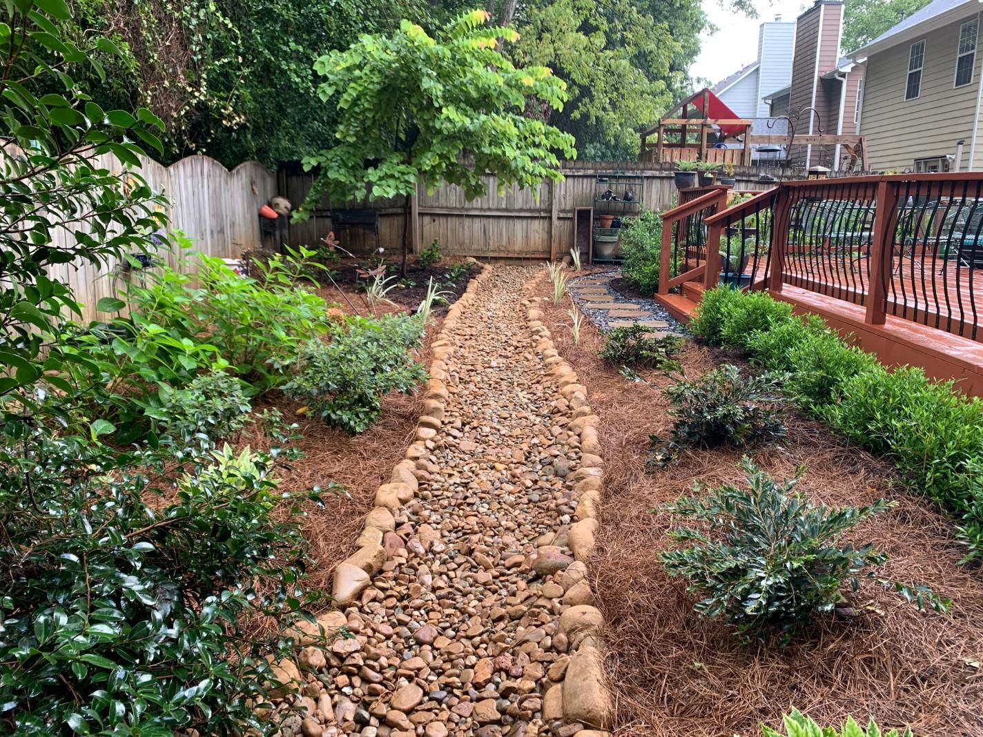 A stone path leading to a deck in a backyard.