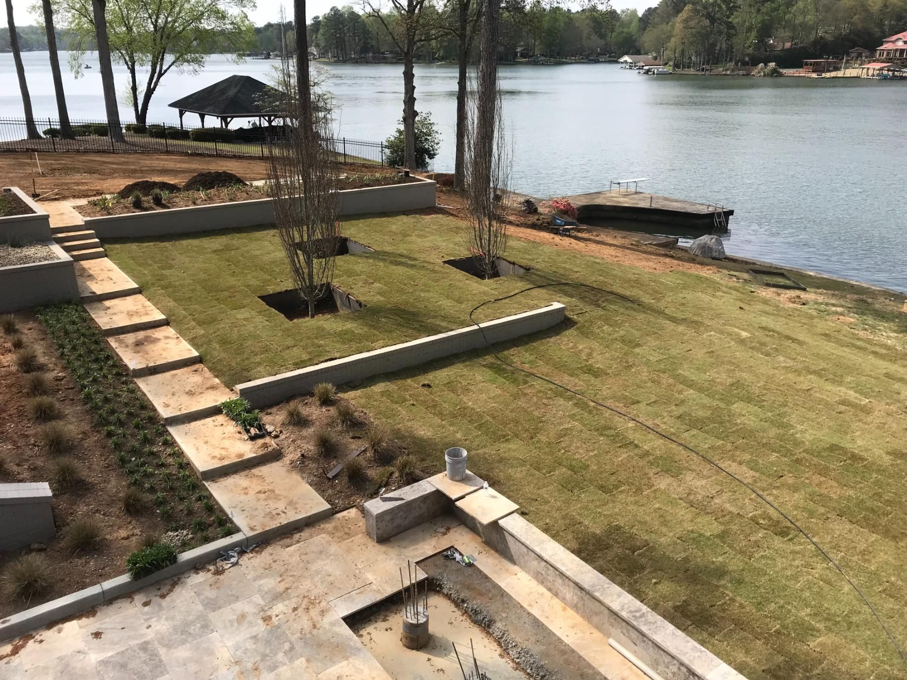 An aerial view of a lush green lawn next to a lake.