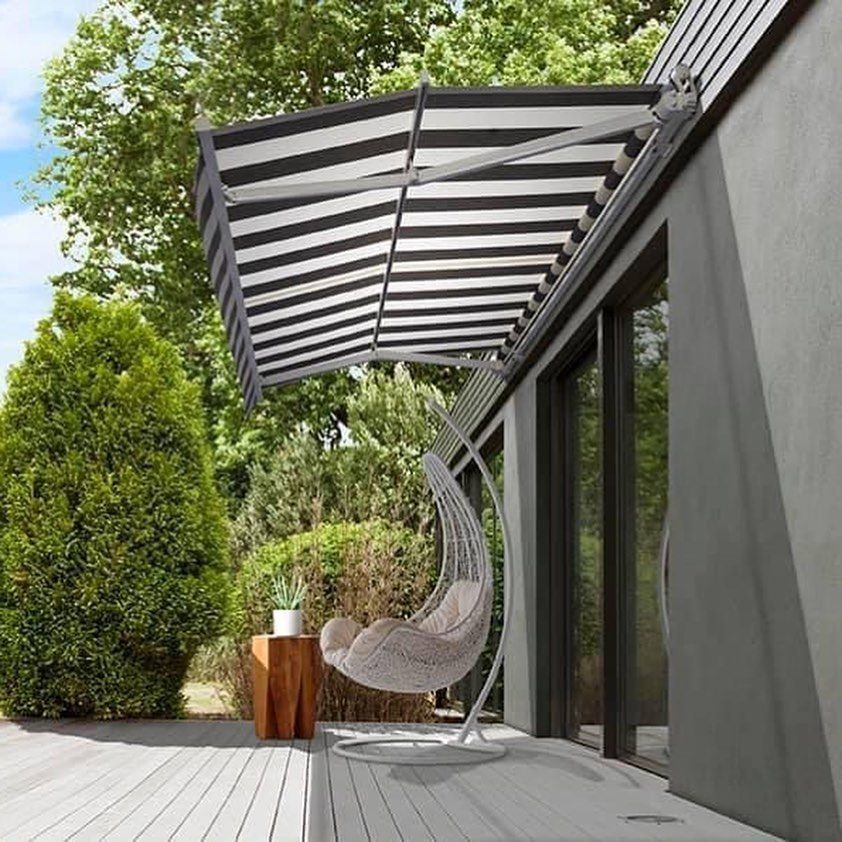 Striped Awning Over Outdoor Seating Area With a Hanging Chair and Wooden Table — BlindDESIGN in Byron Bay, NSW