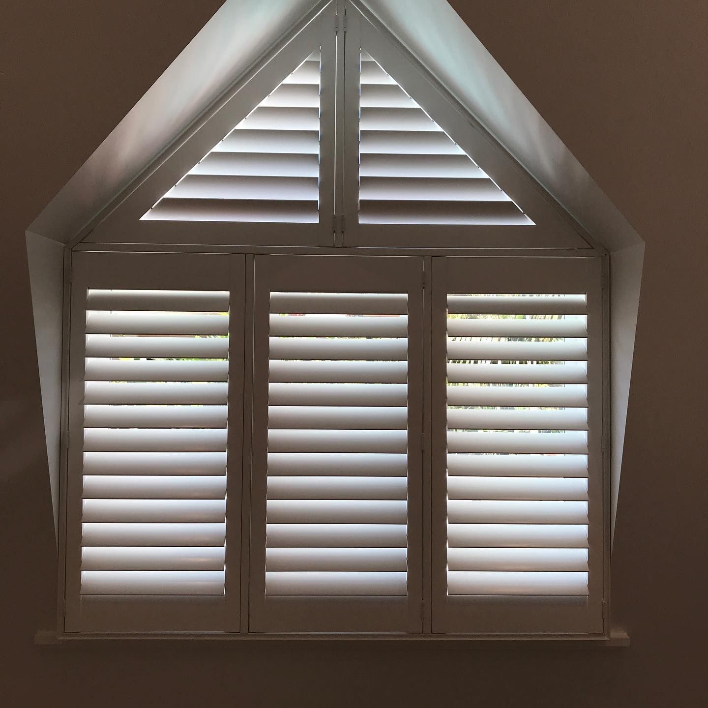 White Shutters Cover a Triangular Window — BlindDESIGN in Byron Bay, NSW