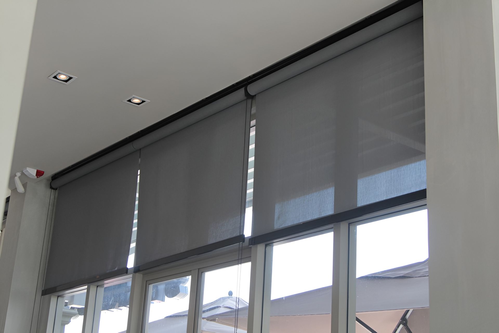 Gray Roller Blinds Covering a Window, Mounted on A White Ceiling — BlindDESIGN in Mullumbimby, NSW