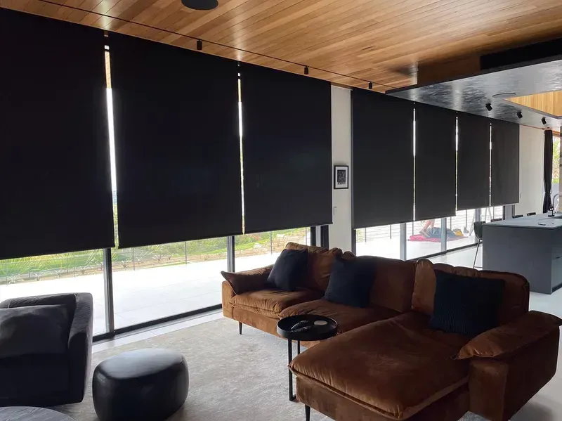 Living Room With Black Roller Shades, Brown Couch, and Wood Ceiling — BlindDESIGN in Byron Bay, NSW