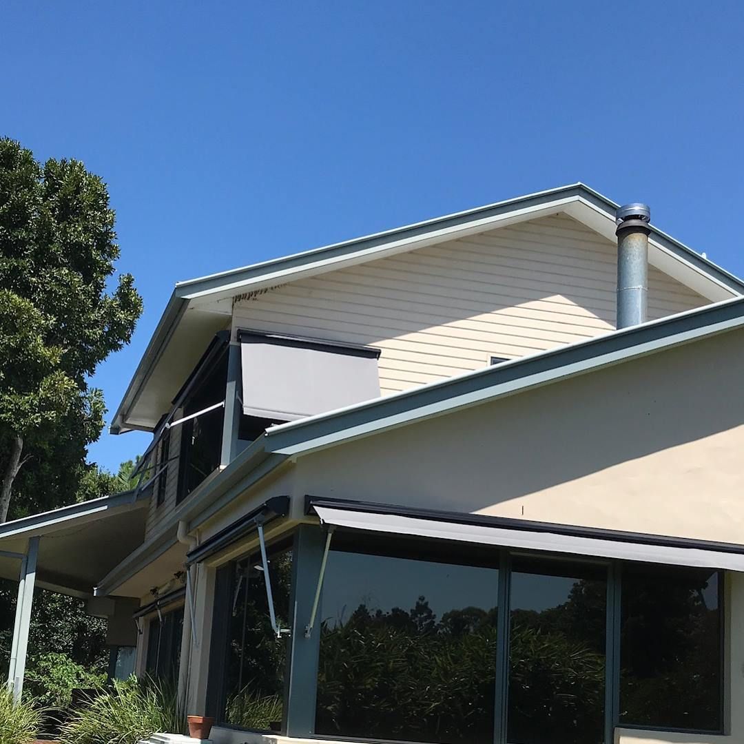 Beige House With Gray Awnings, Dark Windows, a Chimney, and a Blue Sky — BlindDESIGN in Byron Bay, NSW