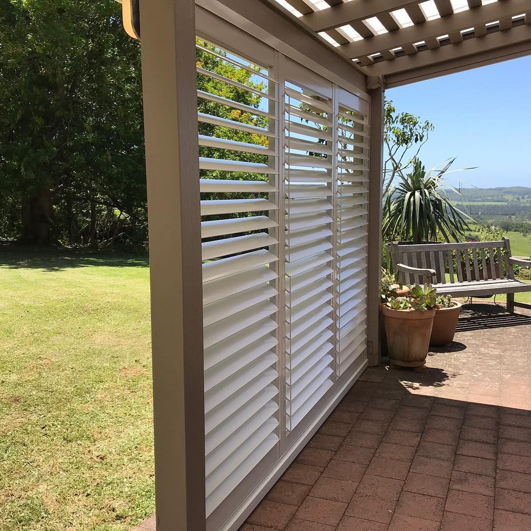 White Shutters on A Patio, Partially Obscuring a View of Greenery — BlindDESIGN in Byron Bay, NSW