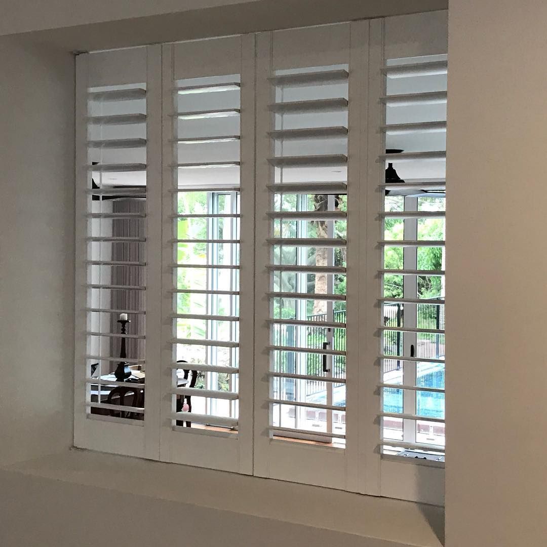 White Shuttered Windows Open to a View of a Backyard With Trees and a Pool — BlindDESIGN in Lennox Head, NSW