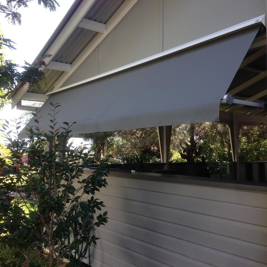 Gray Retractable Awning on a Light Beige House, Providing Shade Outdoors — BlindDESIGN in Byron Bay, NSW
