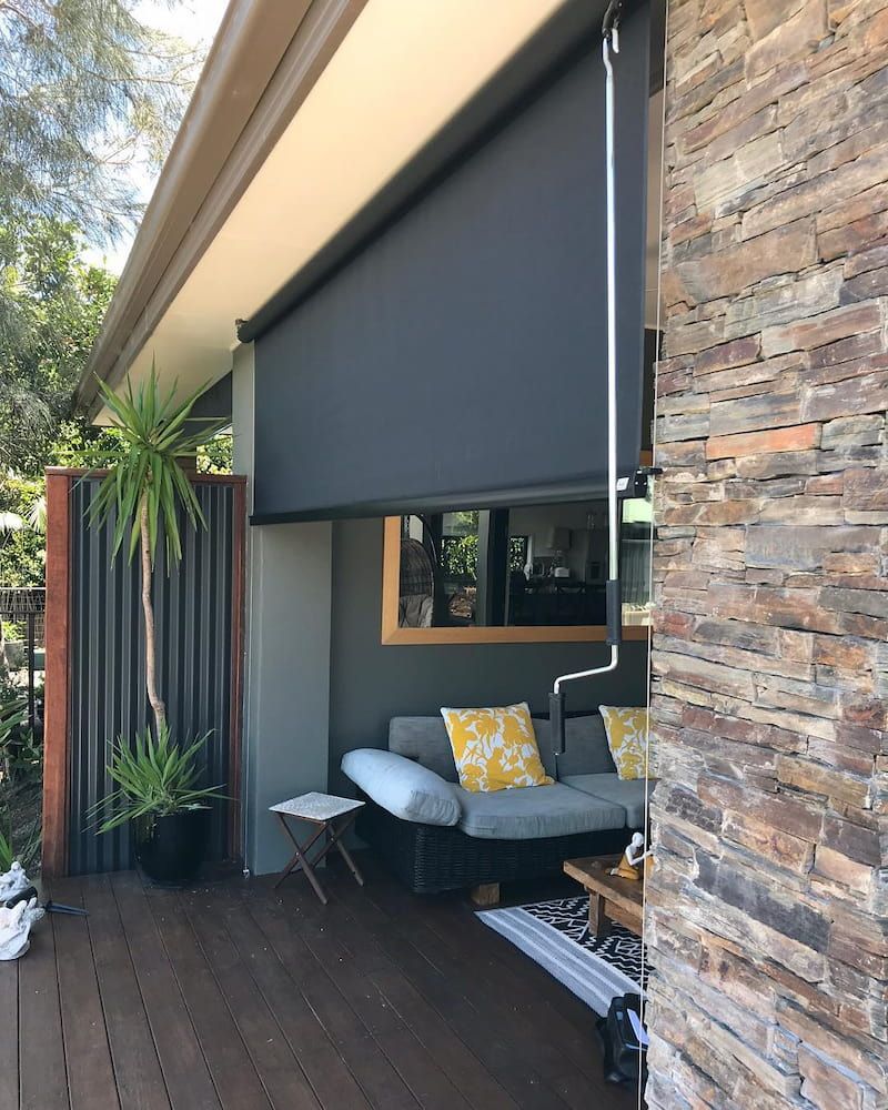 Outdoor Patio With a Retractable Black Shade, a Sofa, and a Stone Wall — BlindDESIGN in Mullumbimby, NSW