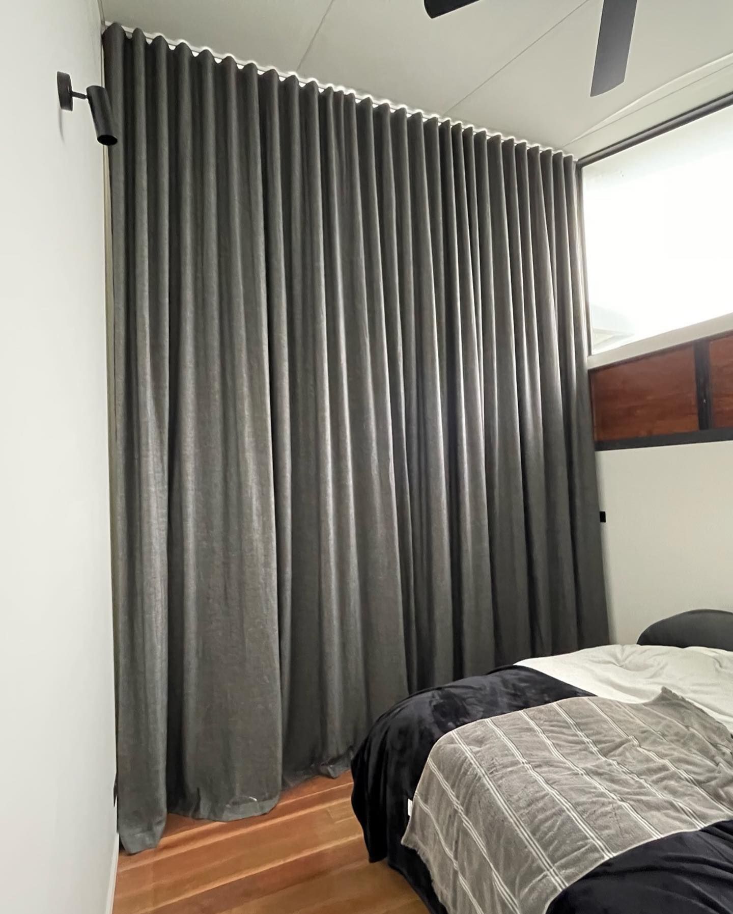 Gray Curtains Covering a Wall in a Bedroom, Partially Obscuring a Bed — BlindDESIGN in Lennox Head, NSW