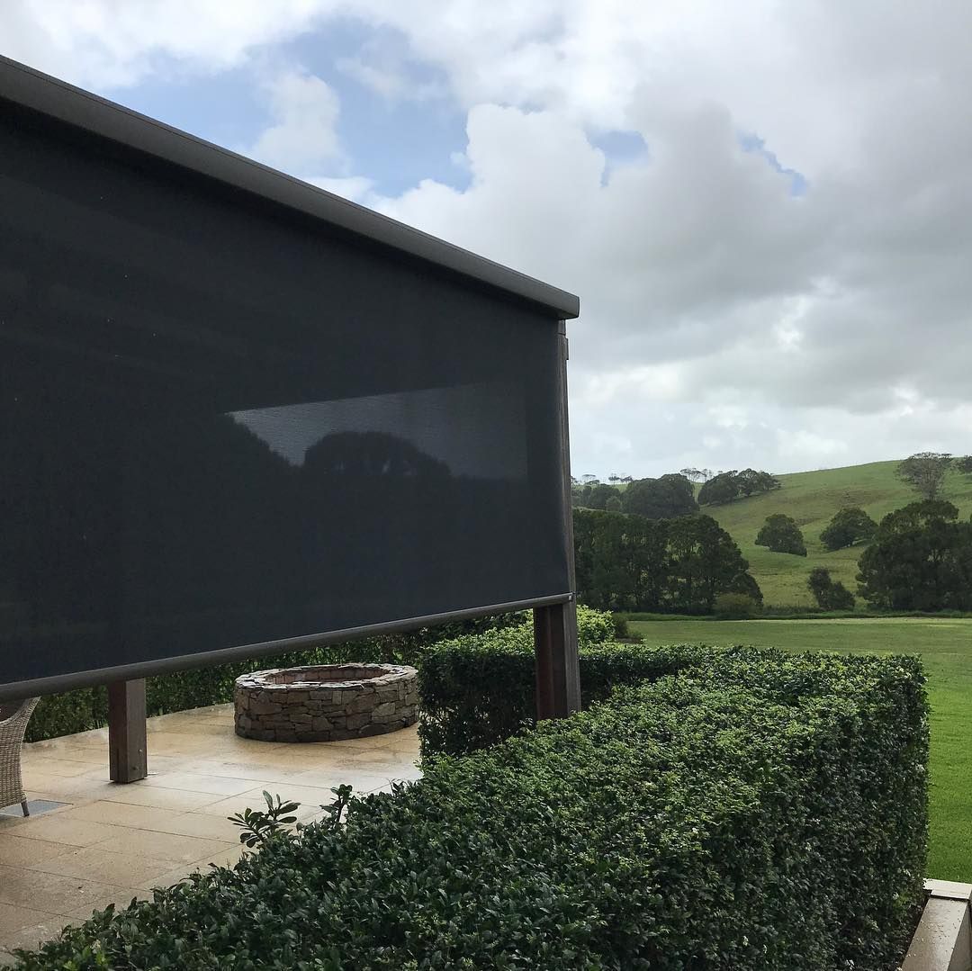 Dark Grey Outdoor Blind Over a Patio, Overlooking a Green Landscape Under a Cloudy Sky — BlindDESIGN in Byron Bay, NSW