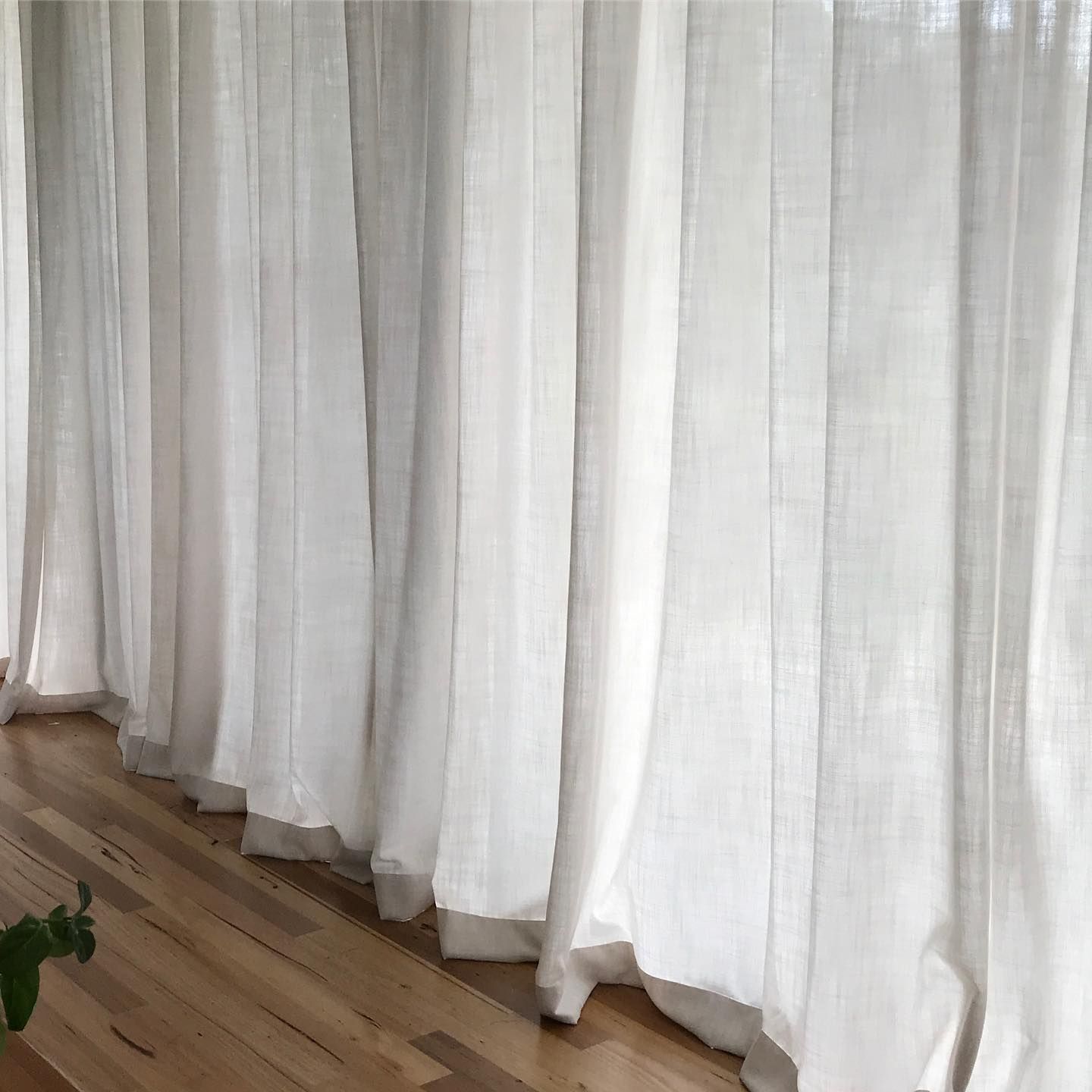 White Sheer Curtains Hanging Next to a Wooden Floor — BlindDESIGN in Tweed Heads, NSW
