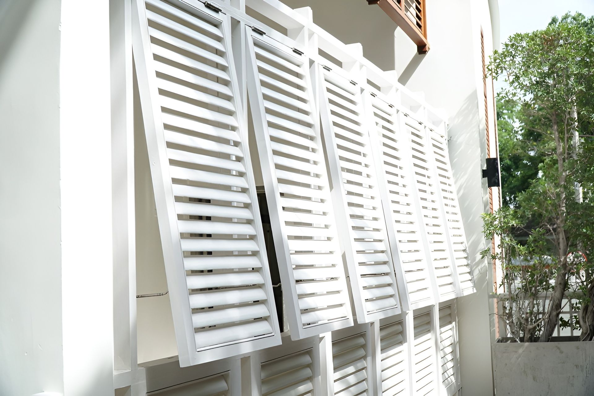 White Slatted Shutters on An Exterior Wall, Partially Open, Casting Shadows — BlindDESIGN in Byron Bay, NSW