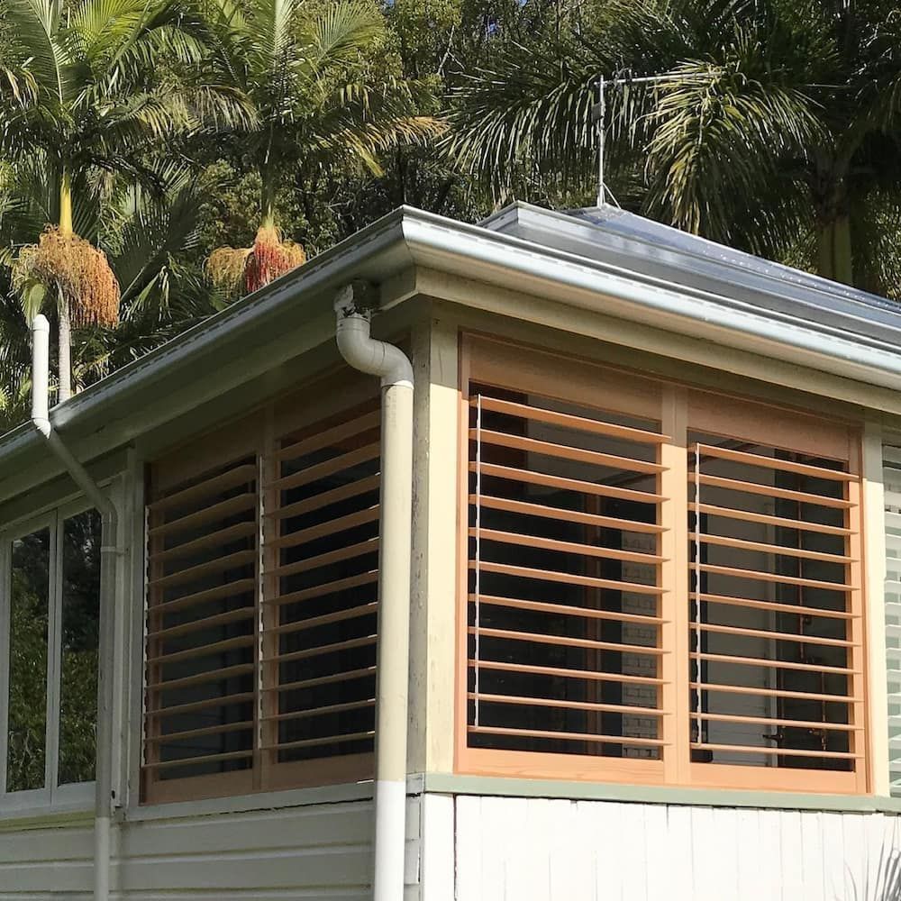 Wooden Shutters on a Building Exterior, With a Gutter and Palm Trees in the Background — BlindDESIGN in Mullumbimby, NSW