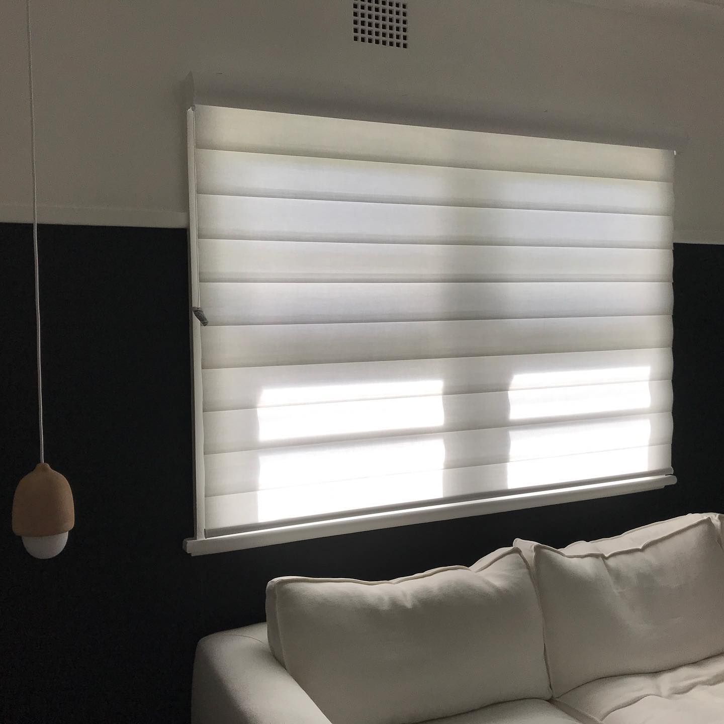 Window with Layered White Shades, Black Wall, White Couch, and Hanging Light — BlindDESIGN in Byron Bay, NSW