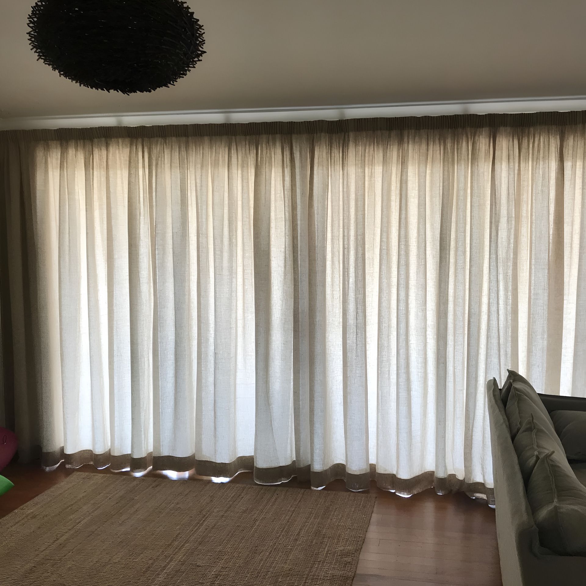 Beige Curtains Draped Over a Window, a Brown Rug on The Floor — BlindDESIGN in Mullumbimby, NSW