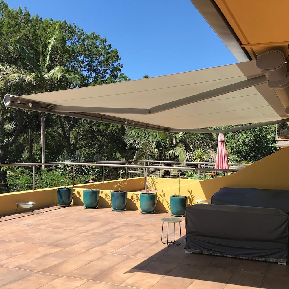 Patio With Retractable Awning, Pots, and Covered Furniture — BlindDESIGN in Lismore, NSW