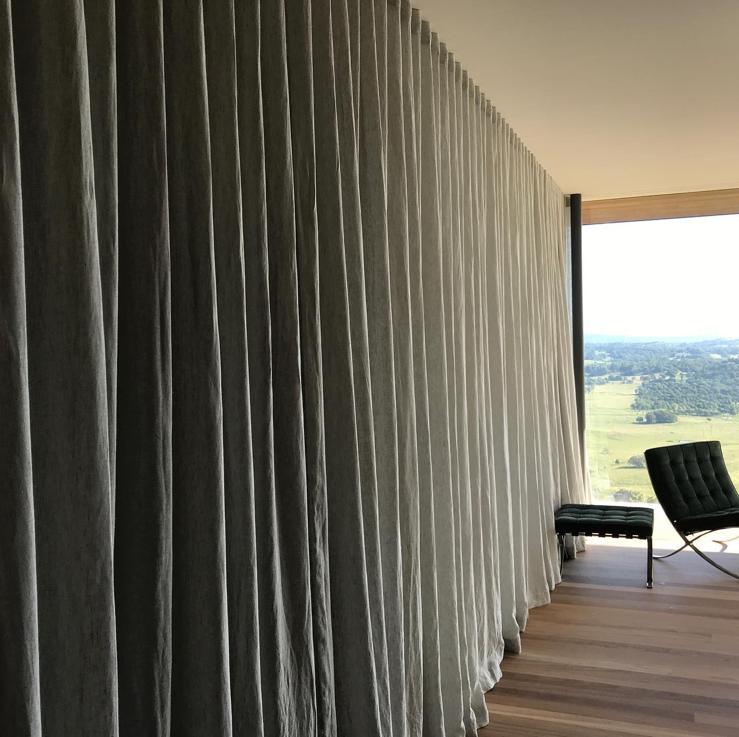 Floor-to-ceiling Pleated White Curtains Beside a Large Window Overlooking a Landscape — BlindDESIGN in Byron Bay, NSW