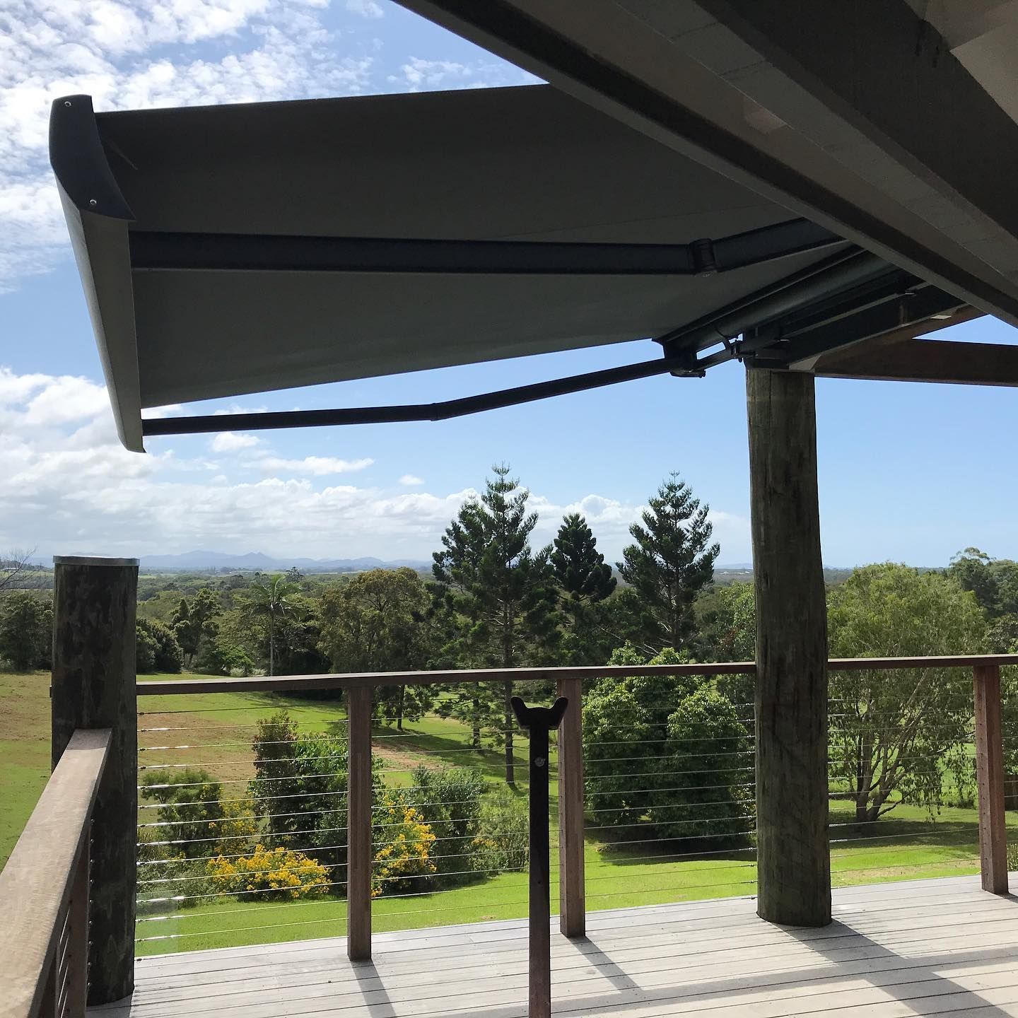 An Awning Extends Over a Wooden Deck, Overlooking a Green Landscape — BlindDESIGN in Lennox Head, NSW