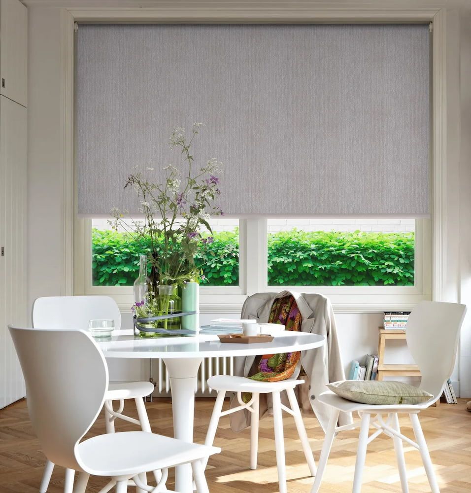 Dining Room With Round Table, White Chairs, and Light Gray Window Shade — BlindDESIGN in Byron Bay, NSW