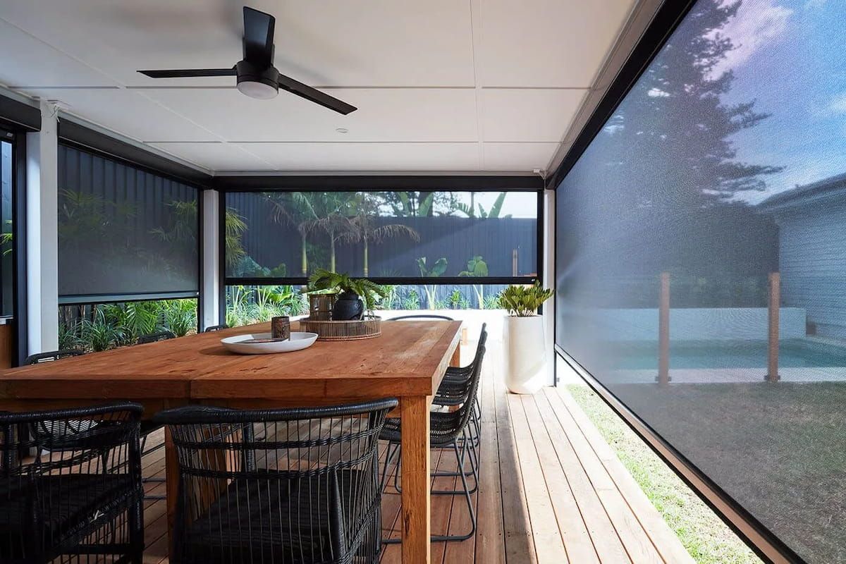 Covered Patio With a Wooden Table and Black Roll-down Shades; View of a Pool and Yard — BlindDESIGN in Mullumbimby, NSW