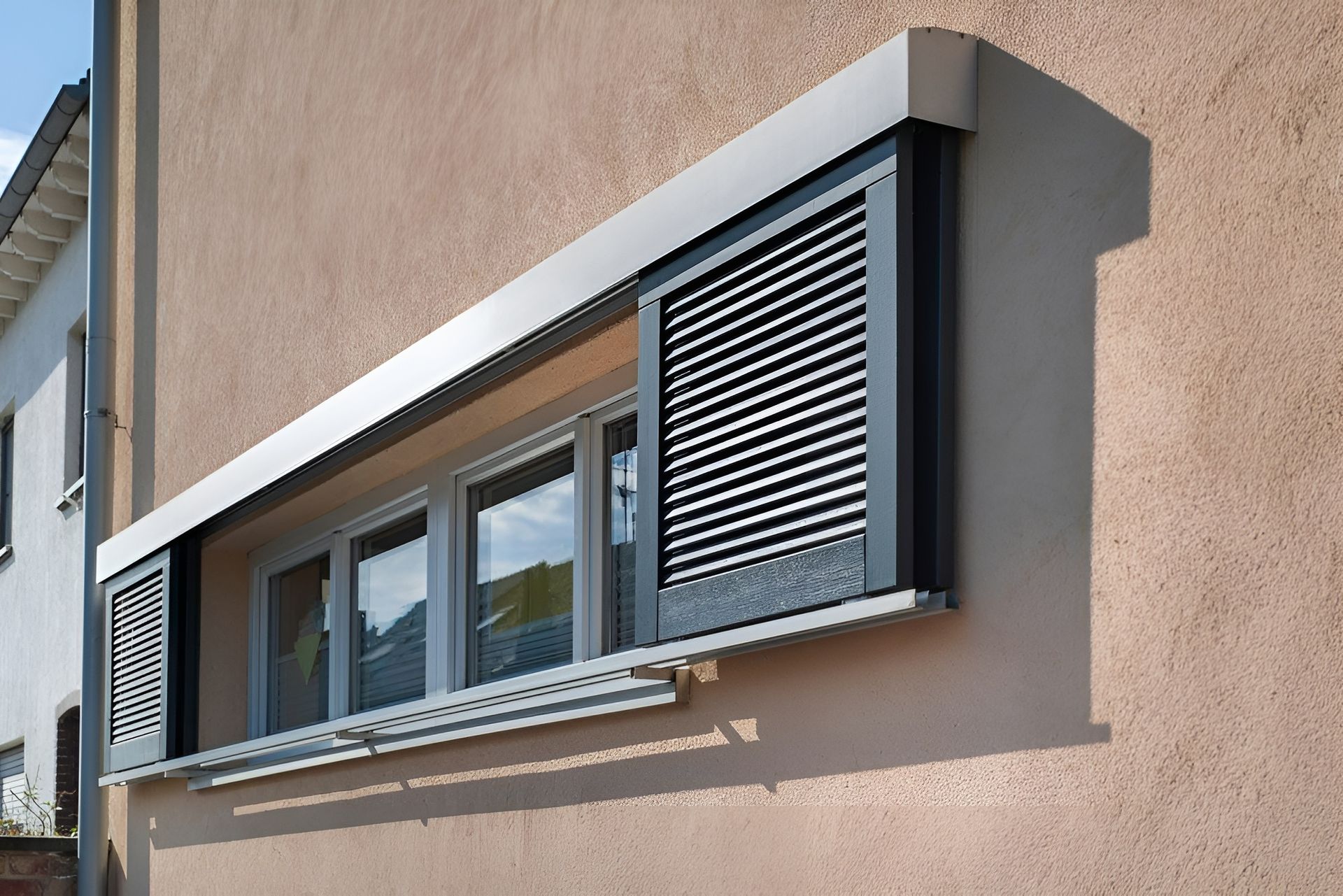 Exterior of A Building with A Long Window Featuring Grey Shutters — BlindDESIGN in Byron Bay, NSW