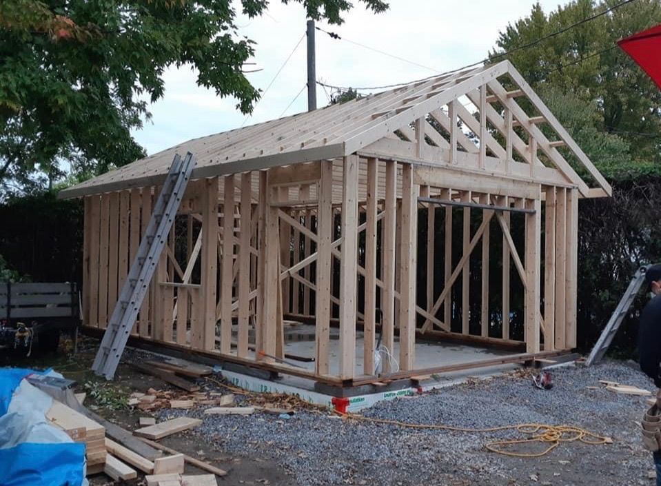 Construction d'une structure d'abri en bois à l'extérieur, avec une échelle et des outils.