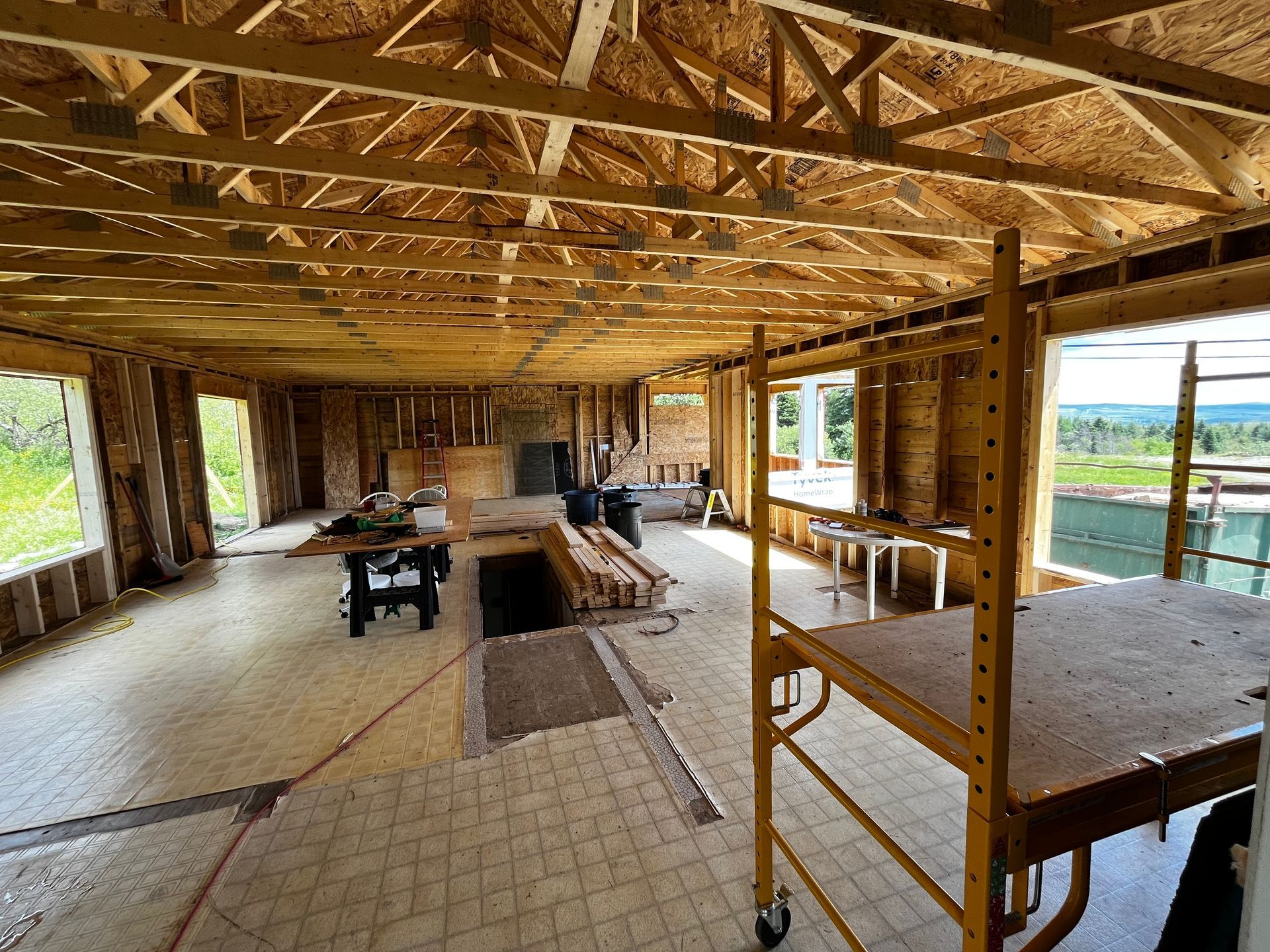 Intérieur d'un bâtiment en construction. Charpente en bois, montants apparents et échafaudage.