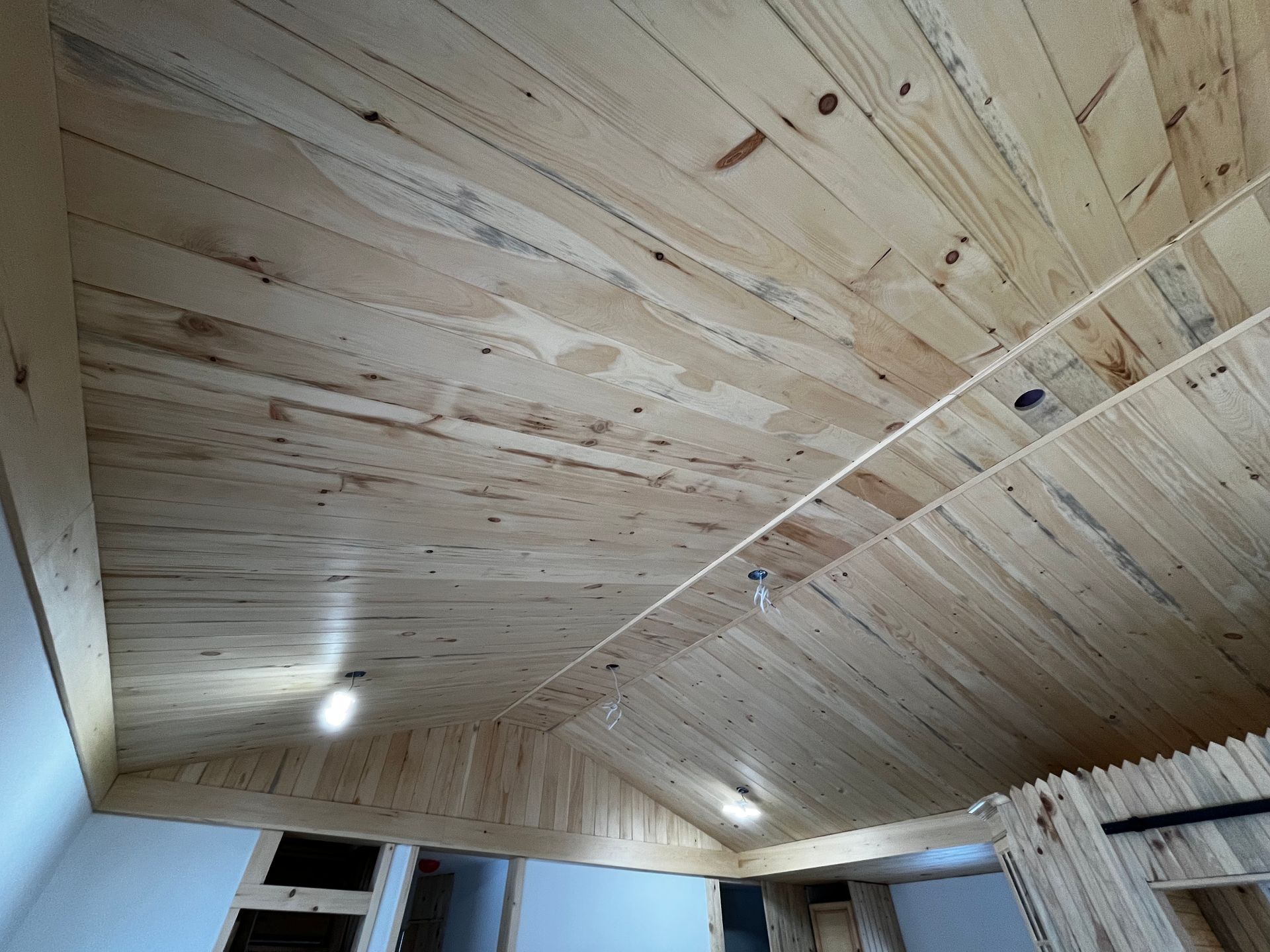 Plafond en bois avec spots encastrés dans une pièce.