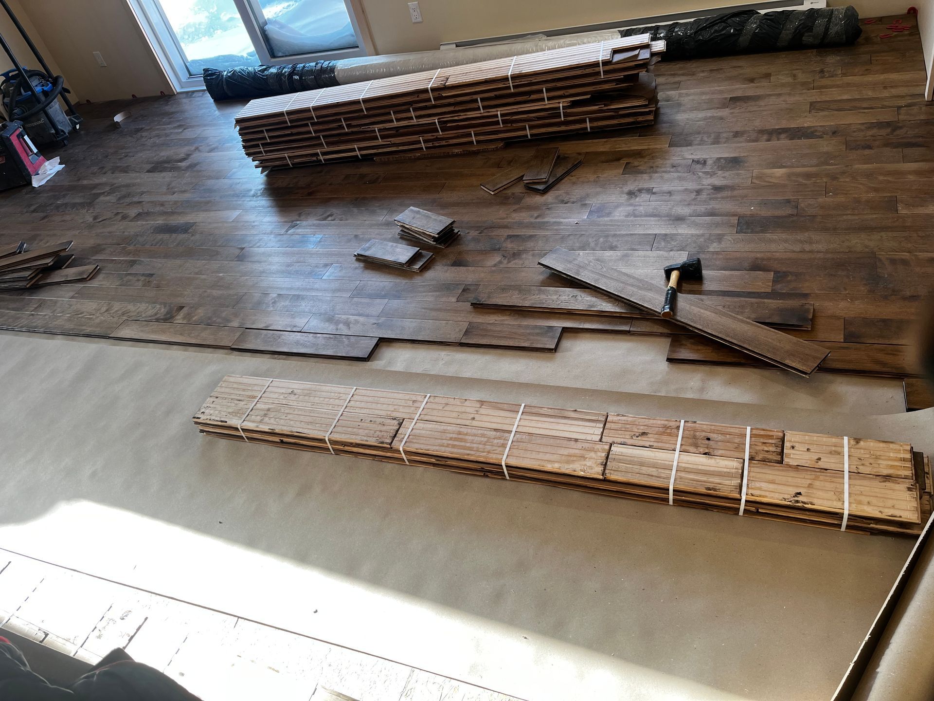 Pose de parquet en cours ; lames empilées et disposées sur une surface claire.