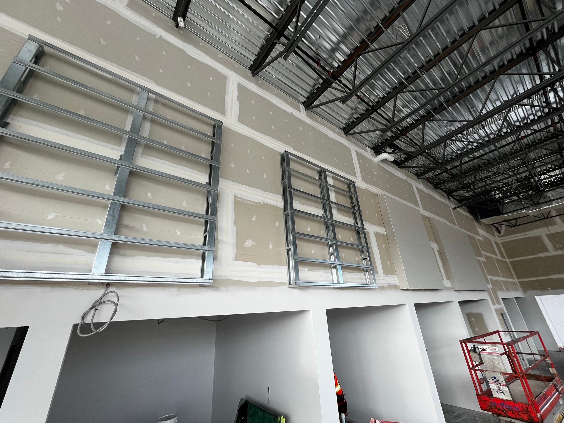 Chantier : mur intérieur avec ossature métallique, plaques de plâtre et haut plafond.