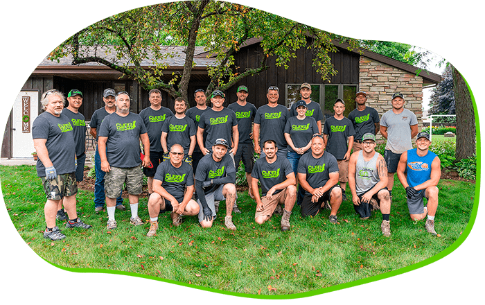 A group of men are posing for a picture in front of a house.
