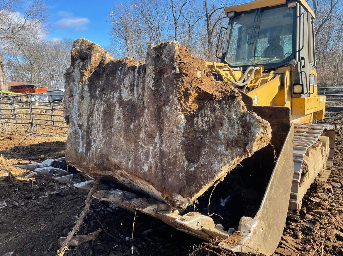 Yellow Bulldozer Moving A Large Rock — Chambersburg, PA — Dave’s Truck Repair Inc. 