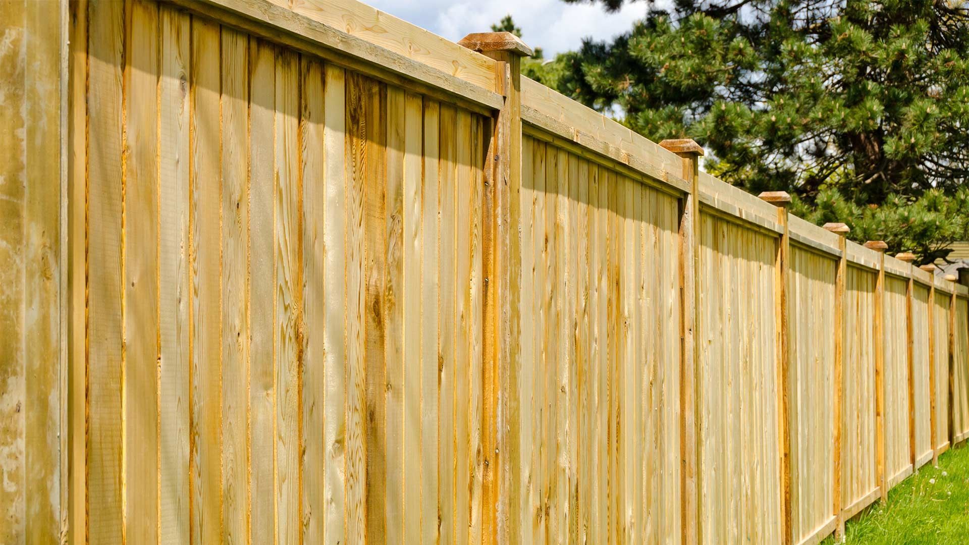 A wooden fence is sitting in the middle of a lush green field.