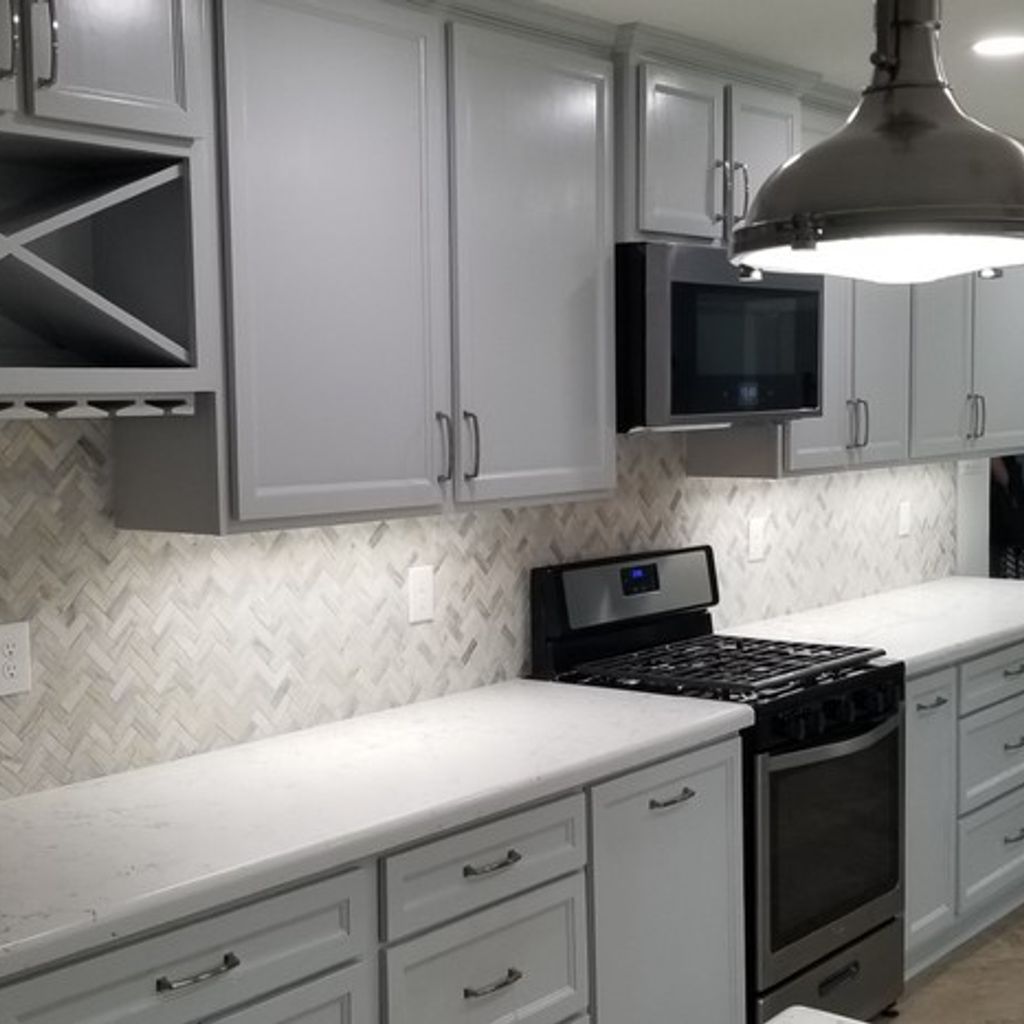 A kitchen with white cabinets and a stove top oven