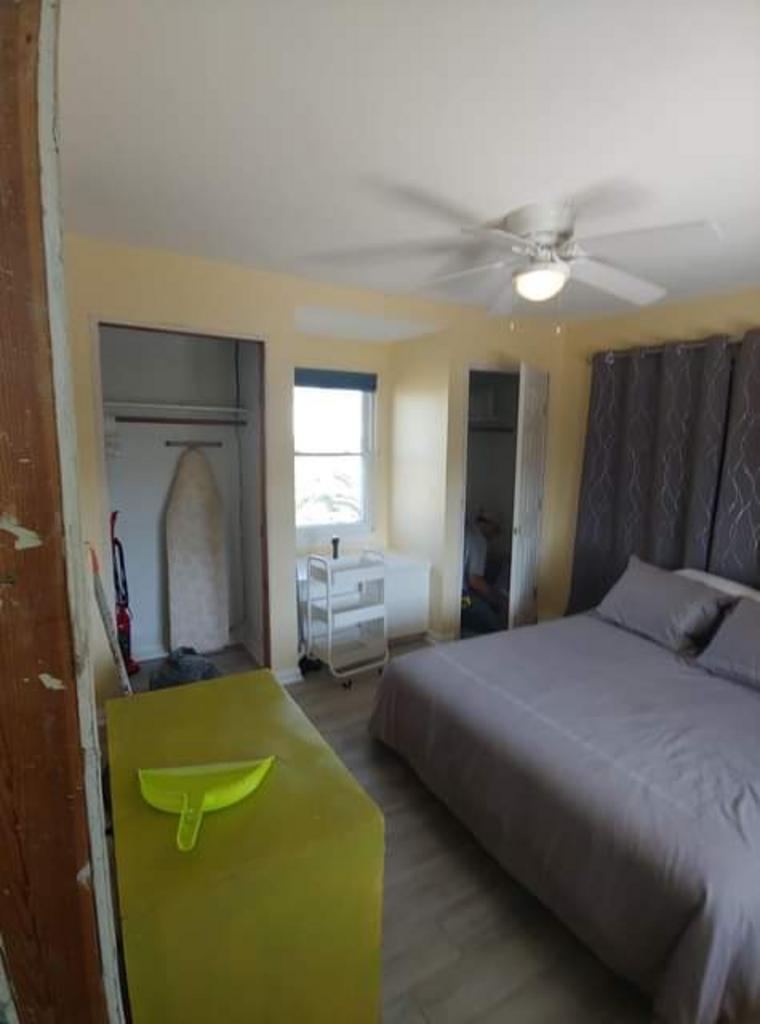 A bedroom with a bed and a ceiling fan.